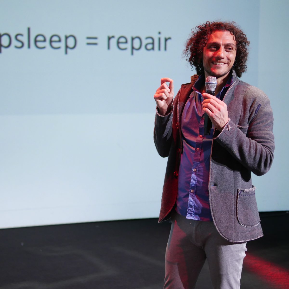 Nima Koucheki speaking on stage